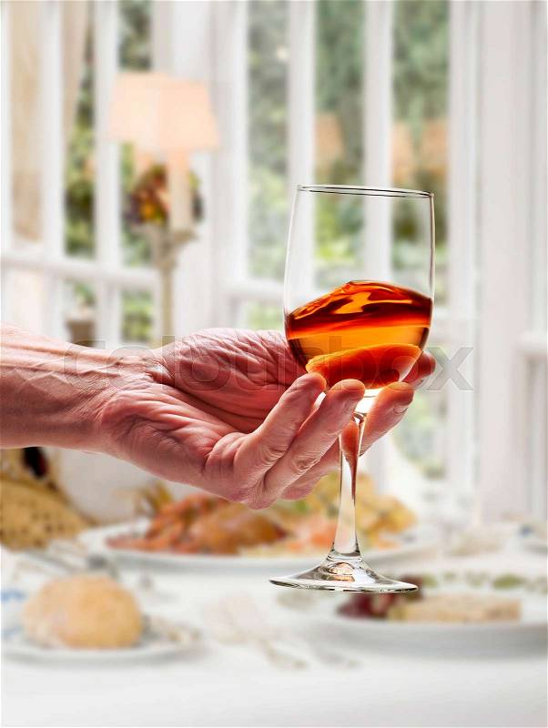 Pink wine swirled in glass in luxury restaurant, stock photo