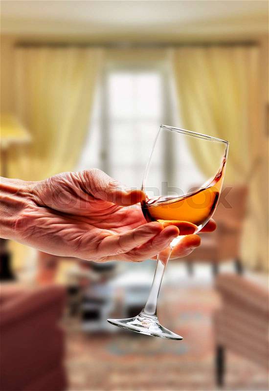 Pink wine swirled in glass in luxury living room, stock photo