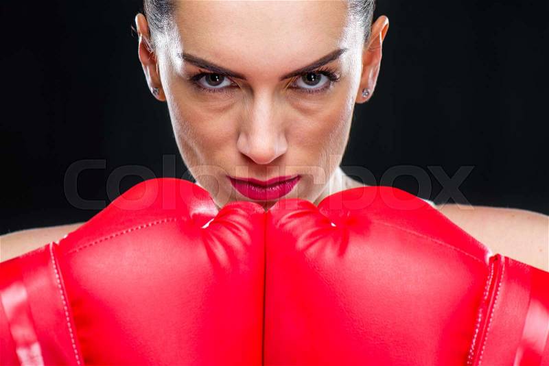 Close-up portrait of young woman in boxing gloves looking at camera, stock photo