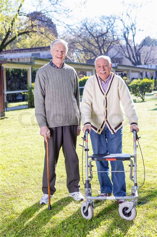 Senior retired friends happy in rehab clinic garden, stock photo