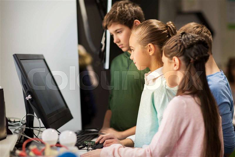 Education, children, technology, science and people concept - group of kids or friends with computer at robotics school lesson, stock photo