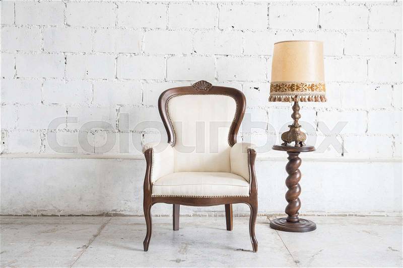 White vintage armchair on white wall, stock photo
