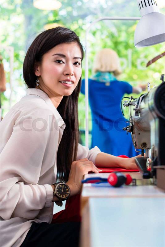Asian tailor woman sewing dress with machine , stock photo
