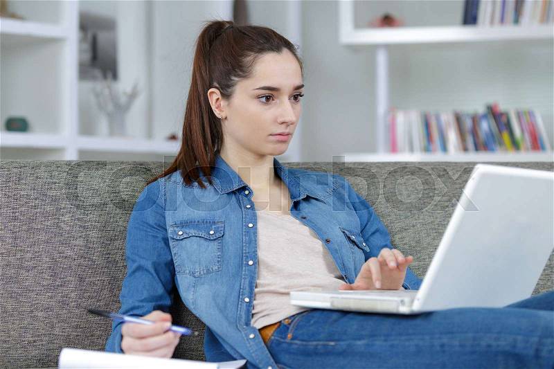 Girl with laptop surfing on the internet, stock photo
