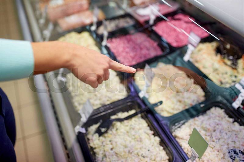 People, shopping, sale and food concept - customer hand pointing at salads on grocery stall, stock photo