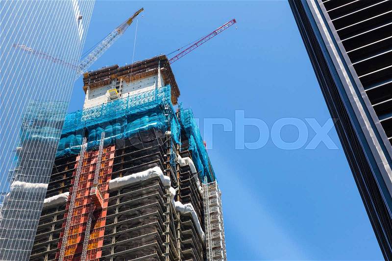 Skyscraper construction with crane on the roof. Urban construction technology, stock photo