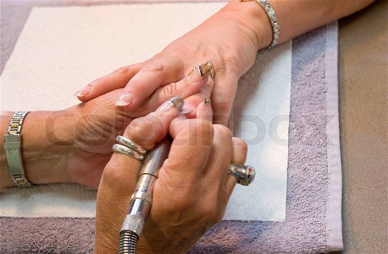 A professional nail technician working on a clients nails, stock photo