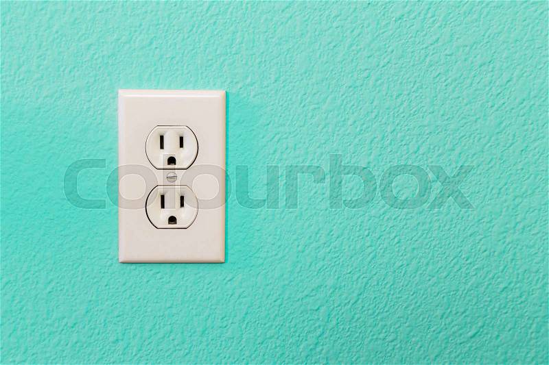 Electrical Sockets In Colorful Bright Teal Wall of House, stock photo