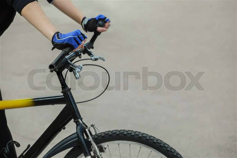 Athlete holding hands handlebar. In the hands of put on blue gloves. Cycling. Healthy lifestyle, stock photo
