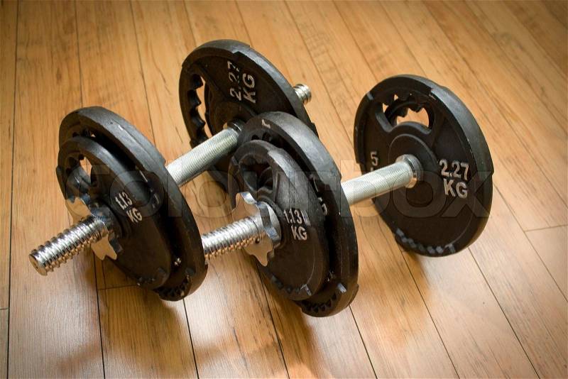 Free weights sitting on a wood floor - the perfect accessory to any home gym, stock photo