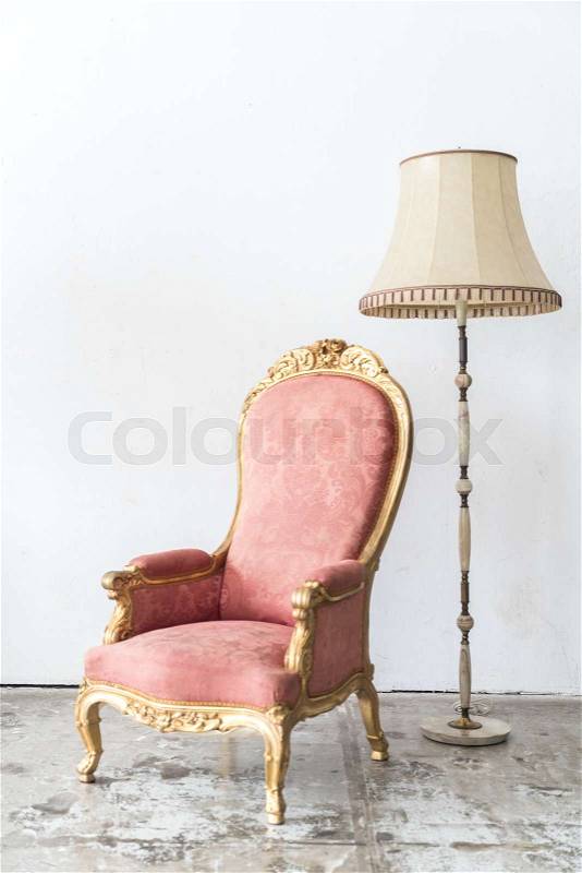 Pink vintage armchair and lamp on white wall, stock photo