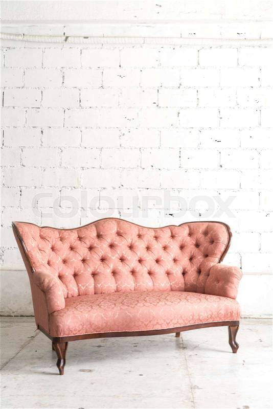 Pink vintage sofa on white wall, stock photo