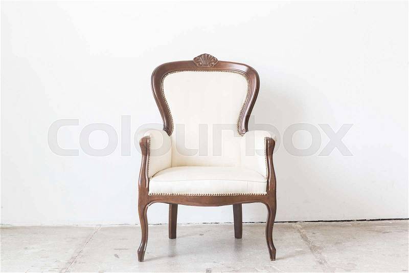 White vintage armchair on white wall, stock photo