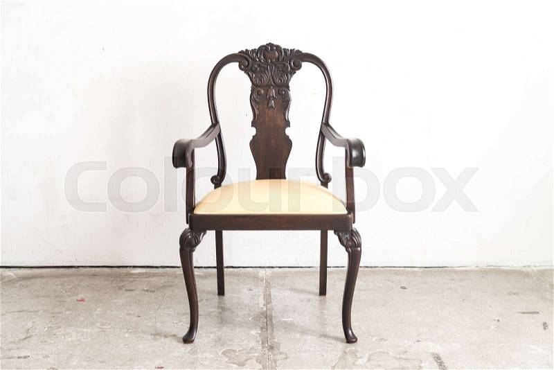Vintage wood armchair on white wall, stock photo