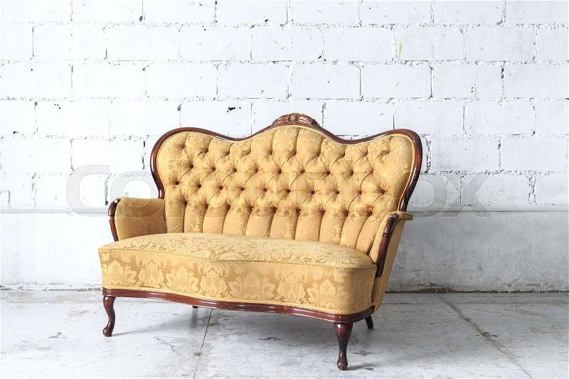 Yellow vintage sofa on white wall, stock photo