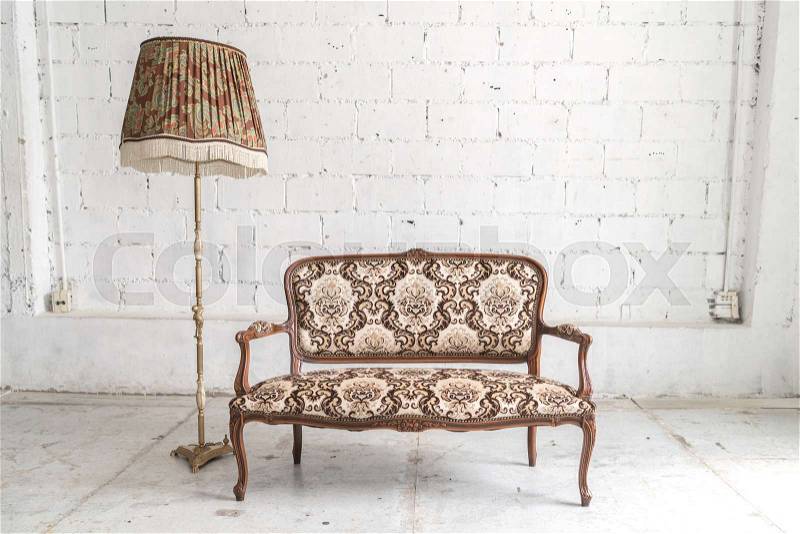 Brown vintage sofa and lamp on white wall, stock photo