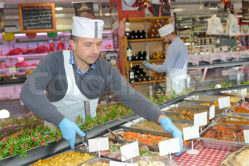 Caterer arranging trays of food, stock photo