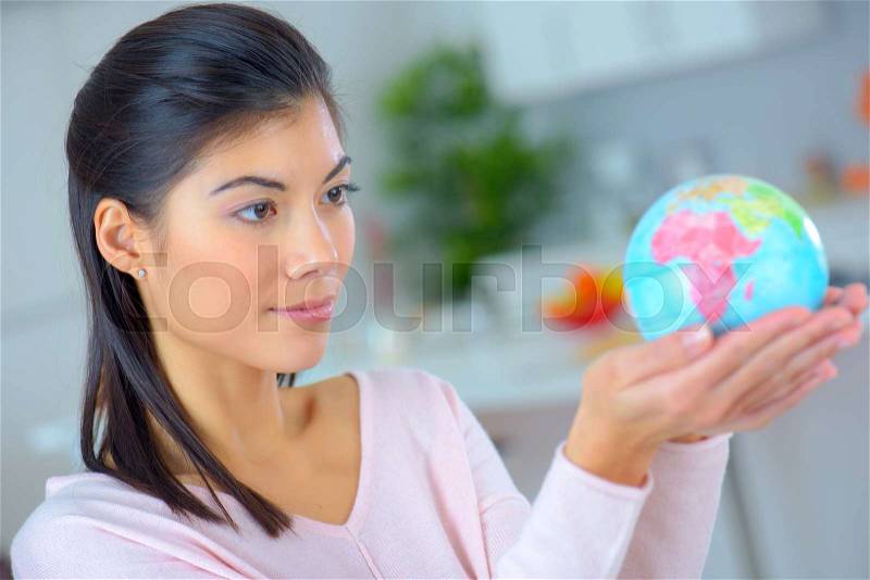 Woman holding a miniature globe, stock photo