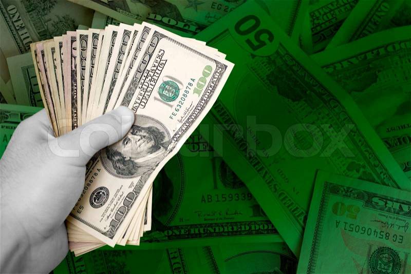 A handful of cash isolated over a green money backgroundPlenty of copyspace, stock photo