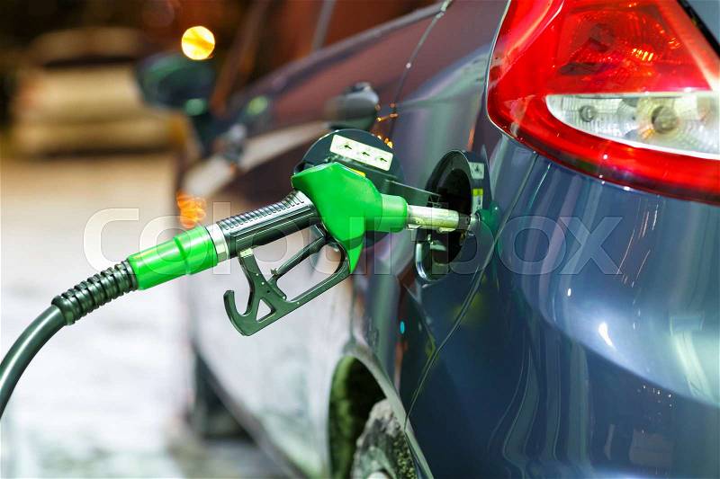 Car refueling on a petrol station in winter at night closeup, stock photo