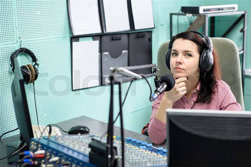 A radio DJ announces news in a radio-studio, stock photo