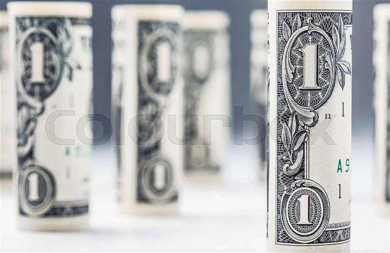Dollar. Dollar banknotes roll in other positions. American US currency on white board and defocused background, stock photo