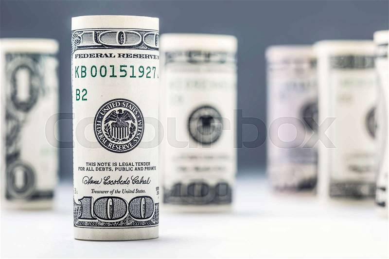Dollar. Dollar banknotes roll in other positions. American US currency on white board and defocused background, stock photo