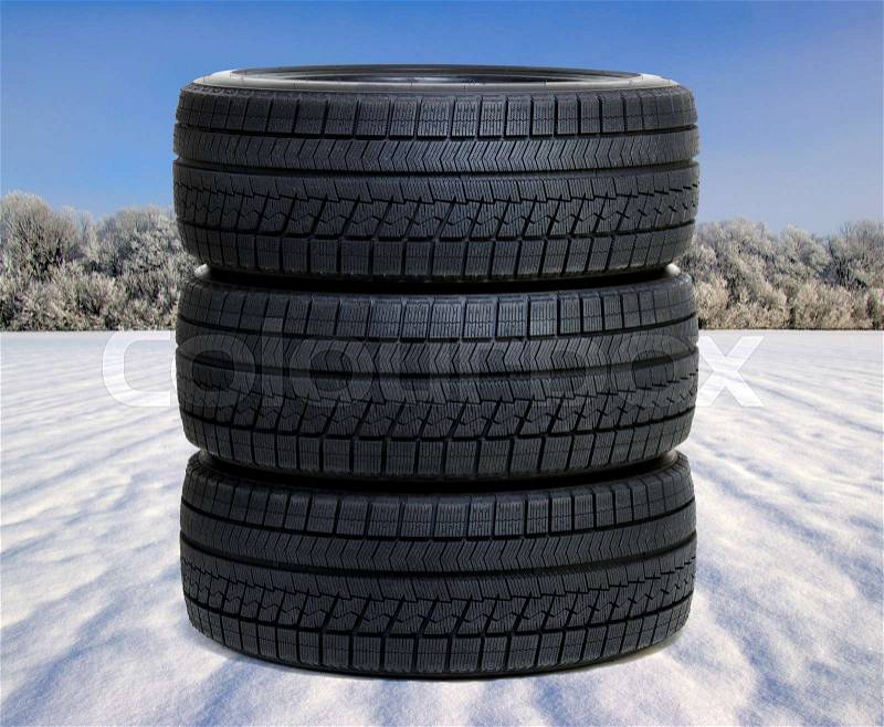 New black tyres for car on snow and frosted trees , stock photo