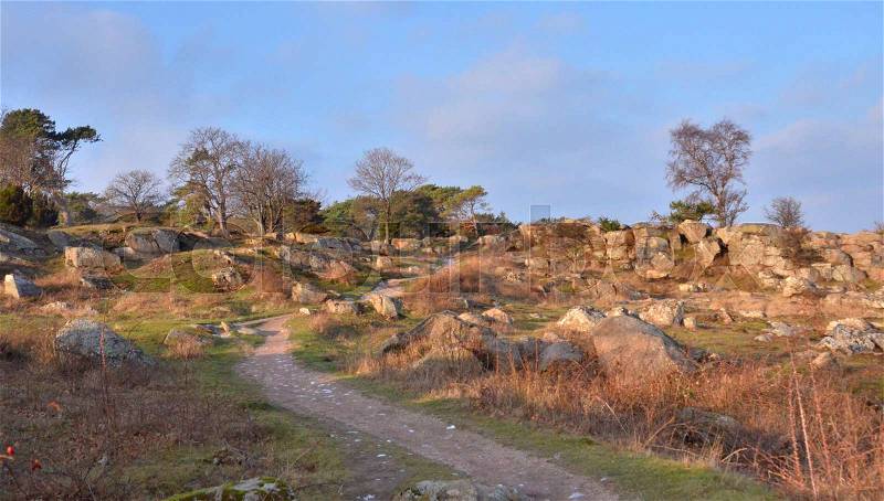 Going for a walk on a Path in the Rocky Landscape, Golden Light and Earthen Colours of Early Winter, stock photo