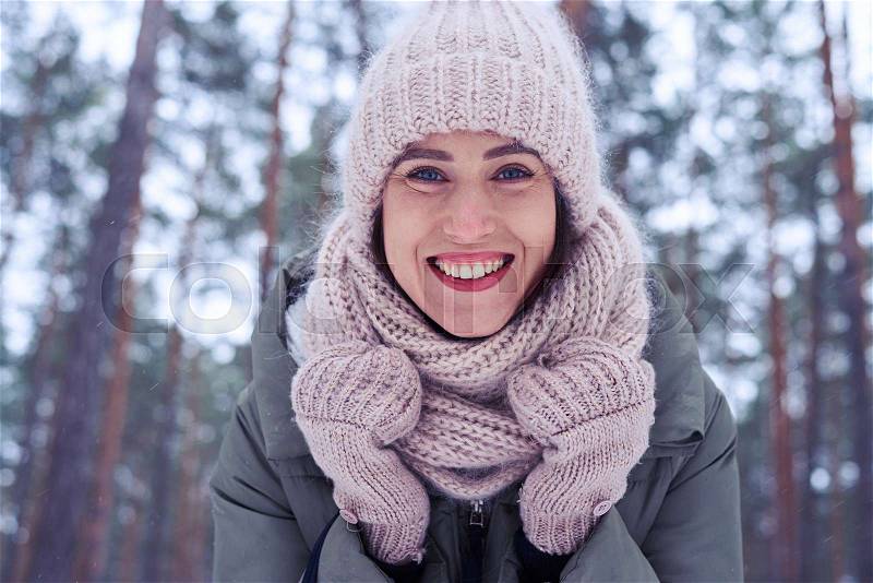 Low angle of woman face with blue eyes and perfect make-up isolated in the wintry forest. A walk in the wintry forest, stock photo