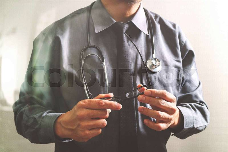 Smart medical doctor holding eyeglass,stethoscope ,front view,filter effect, stock photo