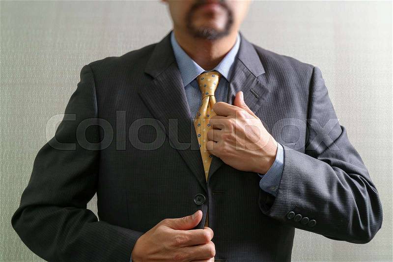 Businessman adjusting tie,Front view, no head. Concept of working in an office, stock photo