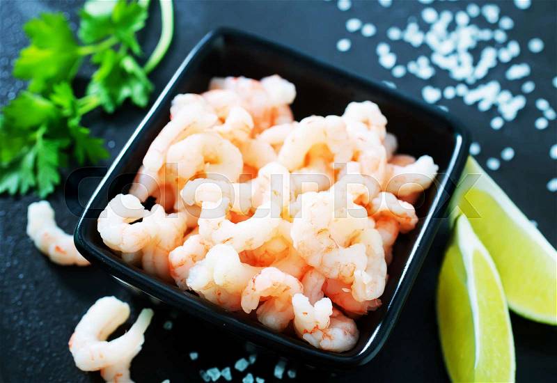 Boiled shrimps in bowl and on a table, stock photo