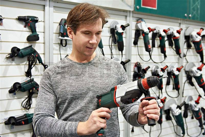 Man shopping for drill in hardware store closeup, stock photo