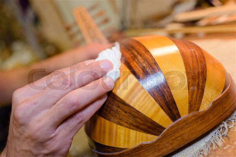 Hand polishing musical instrument, stock photo