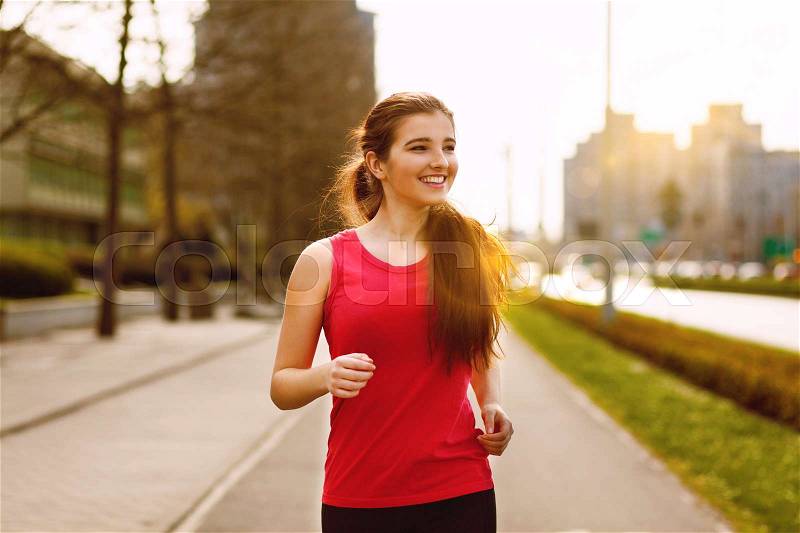 Young beautiful woman running in the city, stock photo