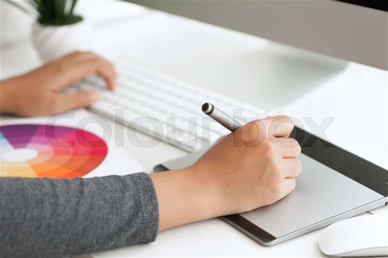 Close up graphic design using digital pen tablet on desk workspace, stock photo