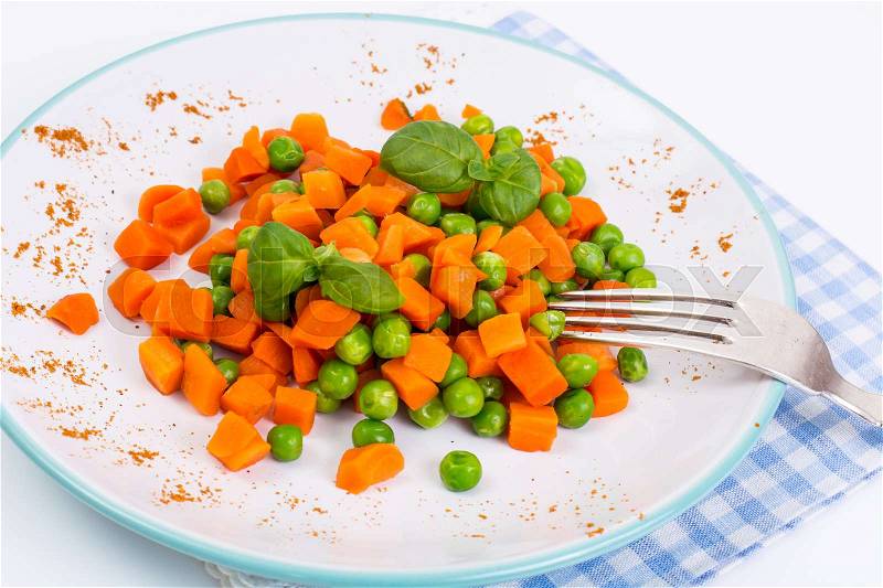 Mix orange carrots and green peas with olive oil and curry. Studio Photo, stock photo