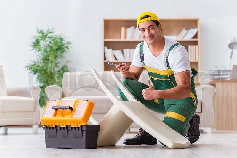 Worker repairing furniture at home, stock photo