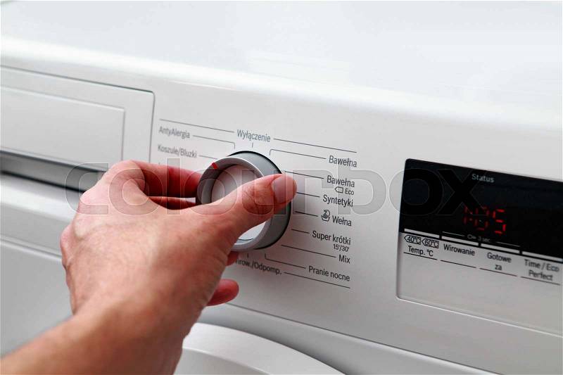 Close up of man hand adjusting washing machine , stock photo