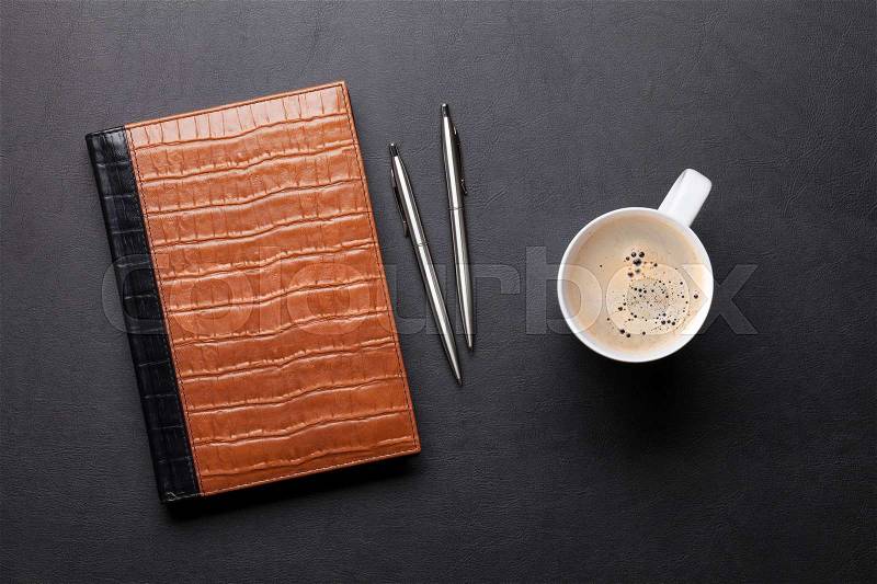 Office leather desk table with notepad, coffee, pen and pencil. Top view, stock photo