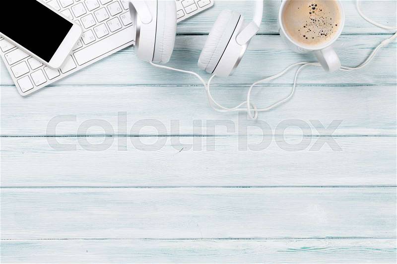 Headphones, phone and pc on wooden desk table. Music concept. Top view with copy space, stock photo