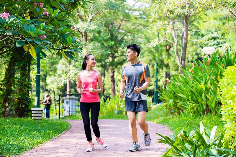 Asian Chinese man and woman jogging in city park, stock photo