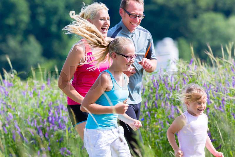 Family running for better fitness in summer through beautiful landscape, stock photo