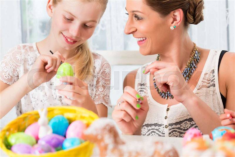 Family having fun coloring Easter eggs, stock photo