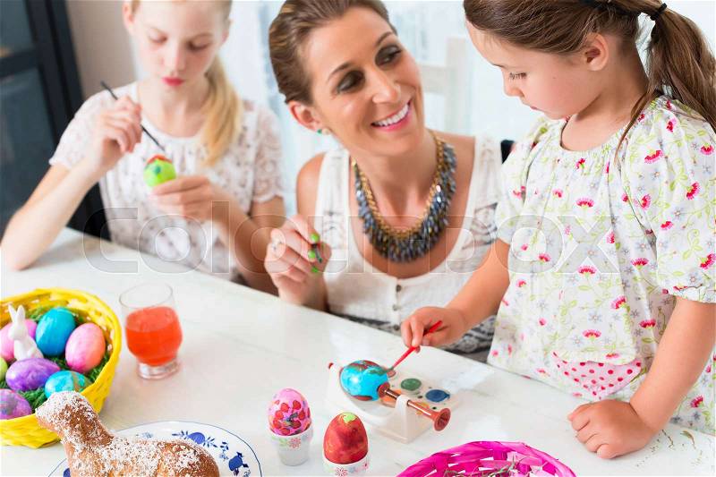 Family having fun coloring Easter eggs, stock photo