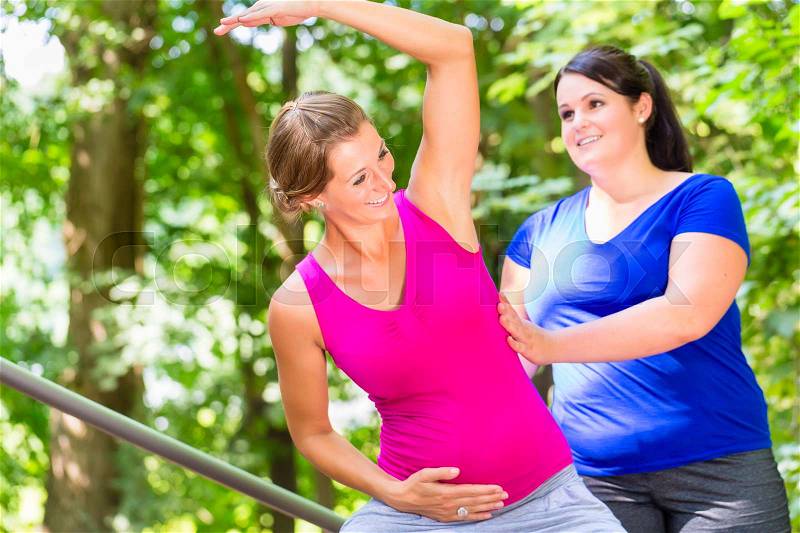 Women doing pregnancy fitness exercises together, stock photo