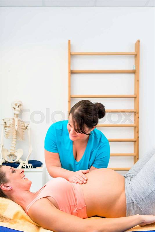 Pregnant woman at physical therapy on couch, stock photo