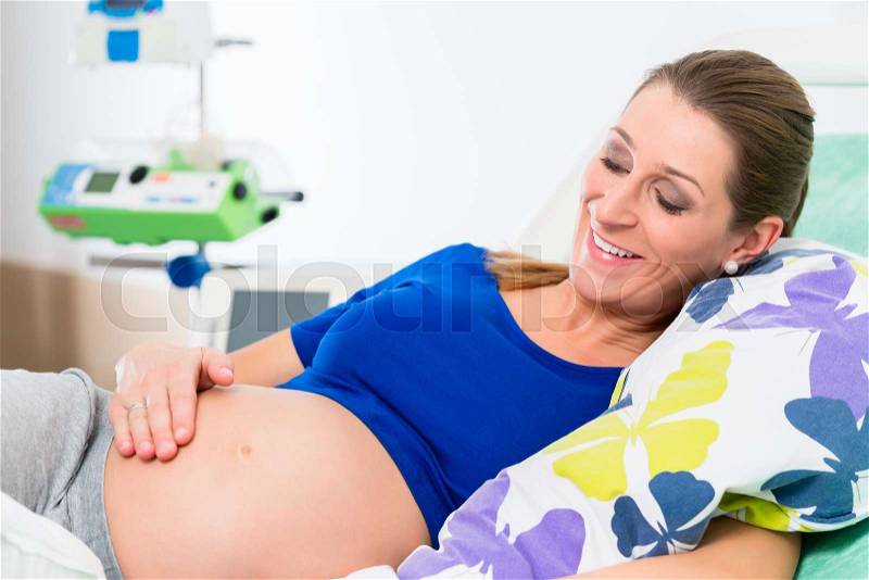 Pregnant woman in delivery room waiting to give birth, stock photo