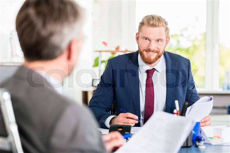 Manager signing documents at the office, stock photo